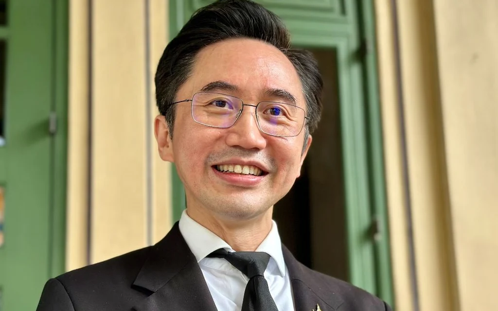 Portrait of Anutin Charnvirakul smiling in a suit.