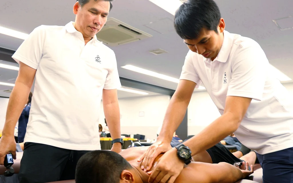 A physiotherapist treating an athlete on a massage table.