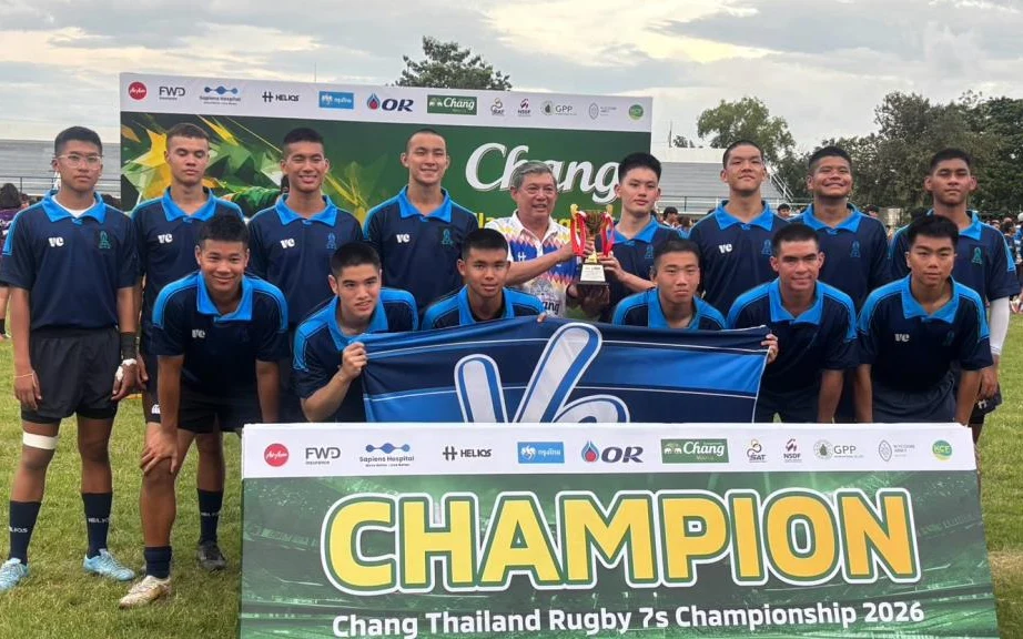 Rugby team posing with a champion banner and trophy