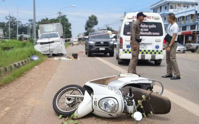 A motorcycle lies on the road at a traffic accident scene.