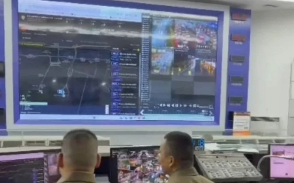 Police officers monitoring traffic surveillance screens in a control room.