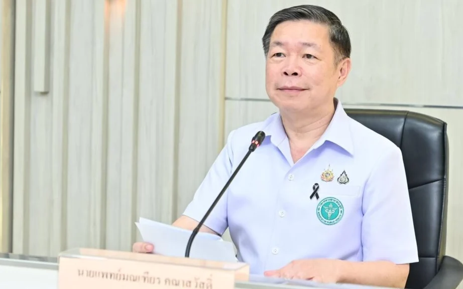 A Thai health official speaking at a podium.