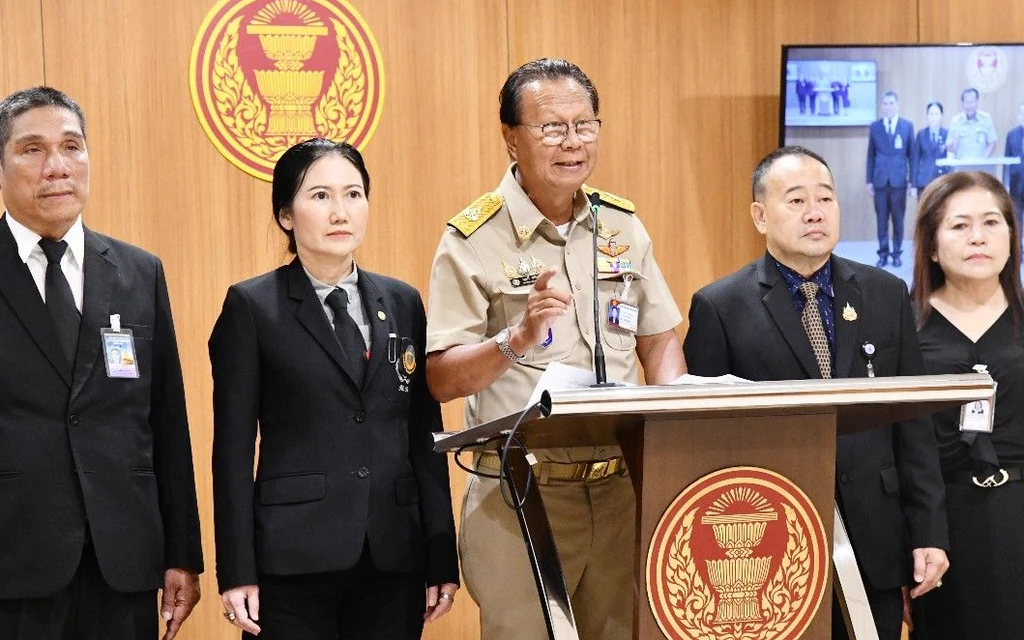Officials give a press briefing at a government podium.