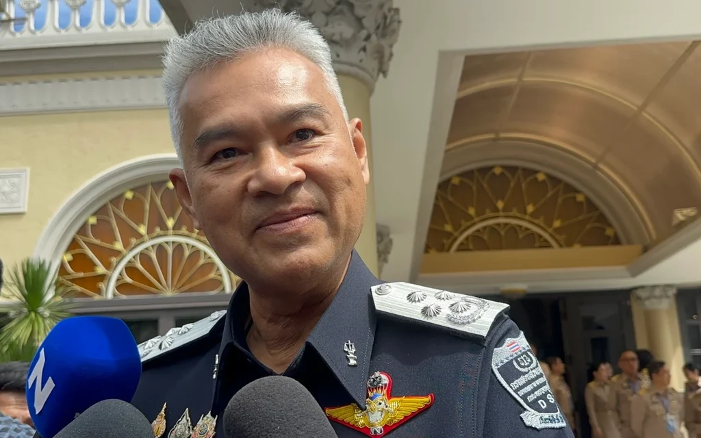 A uniformed official speaks to reporters inside an ornate building.